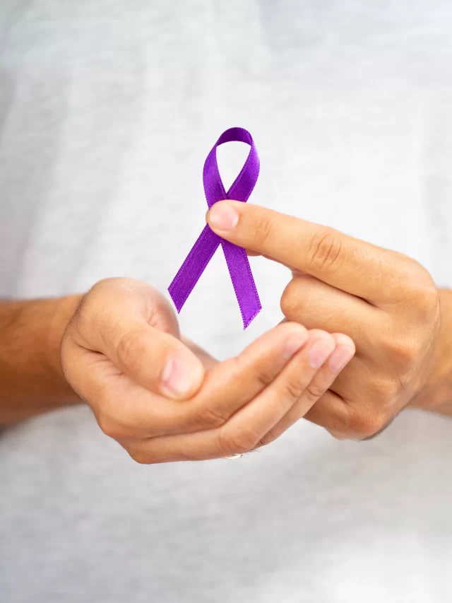 close-up-man-holding-up-purple-ribbon