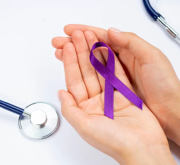 close-up-hands-holding-purple-ribbon-with-stethoscope